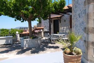 a patio of a house with a table and a tree at Villa Internity in Alikampos