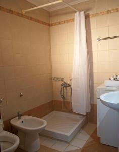 a bathroom with a shower and a toilet and a sink at Villa Internity in Alikampos