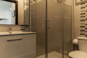 een badkamer met een douche, een toilet en een wastafel bij Casa Terraço in Fuzeta