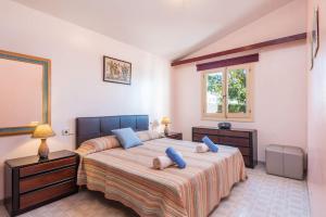 ein Schlafzimmer mit einem großen Bett mit blauen Kissen in der Unterkunft Villa Vera by Villa Plus in Cala'n Bosch + 18 Fotos