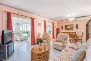 ein Wohnzimmer mit Couch und Fernseher in der Unterkunft Villa Vera by Villa Plus in Cala'n Bosch