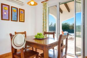 una sala da pranzo con tavolo e sedie in legno di Villa Noa by Villa Plus a Cala'n Bosch