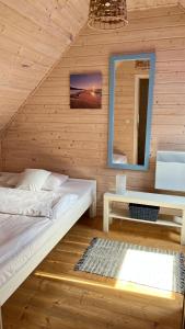 1 dormitorio con 2 camas y espejo en Nadmorska Magia, en Bobolin