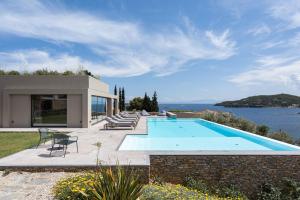 a villa with a swimming pool with a view of the ocean at Pelagoon Skiathos in Achladies