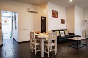 een woonkamer met een tafel en een bank bij Casa Terraço in Fuzeta +19 foto's