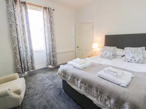1 dormitorio con 1 cama grande y 2 toallas. en North Segganwell - Culzean Castle, en Maybole