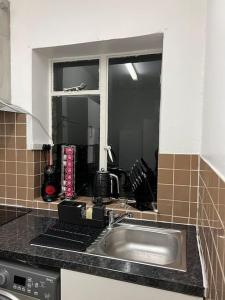 a kitchen counter with a sink and a window at Lovely 2 bed flat in SOHO! in London