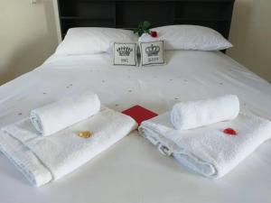 Una cama blanca con toallas encima. en Panoramic Holidays - Deluxe 6, en Peyia