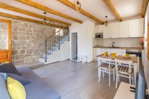 a kitchen and living room with a couch and a table at Olive Garden Apartment in Ston