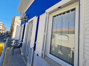 a blue building with a window and a chair on a porch at Dormi da me sul mare in Civitanova Marche