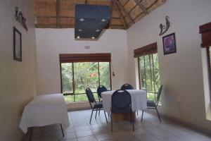 um quarto com uma mesa e cadeiras e uma janela em Copacopa Lodge and Conference Centre em Punda Maria