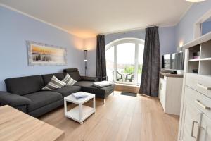 ein Wohnzimmer mit Couch und Fernseher in der Unterkunft "Appartementhaus Deichgraf" Appartement D450 in Döse + 7 Fotos