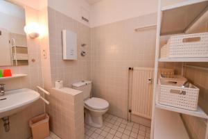 ein kleines Badezimmer mit Toilette und Waschbecken in der Unterkunft "Appartementhaus Deichgraf" Appartement D450 in Döse