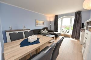 ein Wohnzimmer mit einer Couch und einem Tisch in der Unterkunft "Appartementhaus Deichgraf" Appartement D450 in Döse