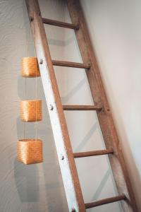 a wooden ladder shelf with three baskets hanging from it at Gîte La Source in Grusse