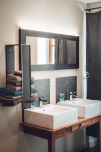 a bathroom with two sinks and a large mirror at Gîte La Source in Grusse