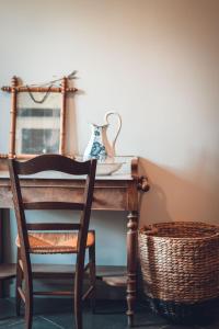 a chair and a table with a vase and a basket at Gîte La Source in Grusse