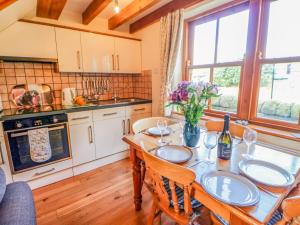 une cuisine avec une table en bois et des chaises ainsi qu'une salle à manger dans l'établissement Moorgair Cottage, à Slaley