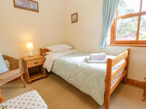 une petite chambre avec un lit et une fenêtre dans l'établissement Moorgair Cottage, à Slaley