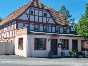 a house with a tiled roof and a white building at Ferienhof Plotzen in Hochkirch