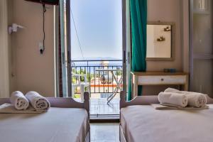 two beds in a room with a view of a balcony at Bob's Apartments in Tolo