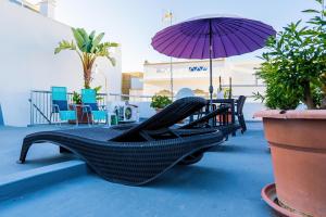 een hangmat en een parasol op een patio bij Casa Terraço in Fuzeta