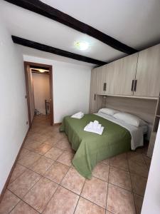 a bedroom with a green bed with towels on it at Casa Ambrosia Tropea in Tropea