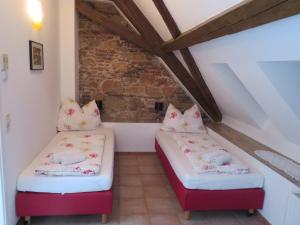 two beds in a room with a brick wall at Bürgerhaus Martinecz in Bad Radkersburg