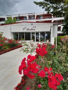 a store with red flowers in front of a building at Hotel Rodica in Venus