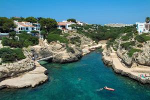 a group of people in boats in a river at Villa Tres Arcos by Villa Plus in Cala en Blanes