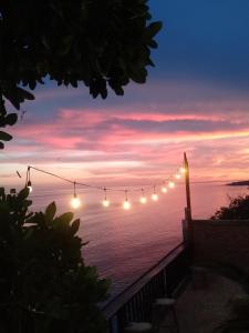 a string of lights hanging over the ocean at sunset at Bara Village Guest House Bira in Bira