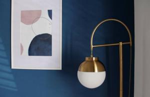 a gold and white lamp on a blue wall at Apartments Marković in Kotor