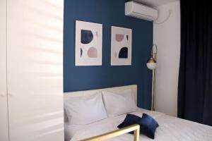 een slaapkamer met een blauwe muur en een bed met kussens bij Apartments Marković in Kotor