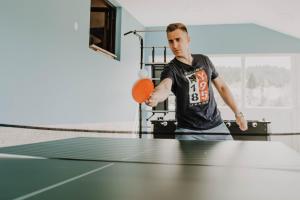 un hombre está jugando al ping pong en Vila Angelina, en Kušići