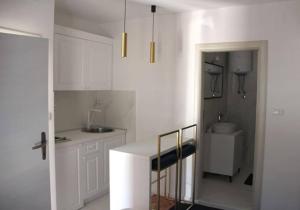 a white kitchen with a counter and a sink at Apartments Marković in Kotor