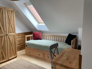 a bedroom with a bed and a desk and a window at Domek Pod Lasem 45,1 Ostoja Bukowo in Borowy Młyn
