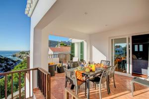 a dining room with a table and chairs on a balcony at Villa Nereida by Villa Plus in Cala en Forcat