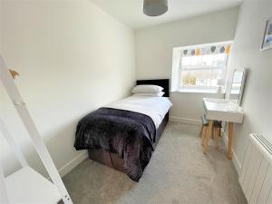 a small bedroom with a bed and a window at Modern 2 Bed Apt Centre Of Penzance, Lift Access in Penzance