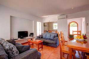 a living room with a couch and a table at Villa Nereida by Villa Plus in Cala en Forcat