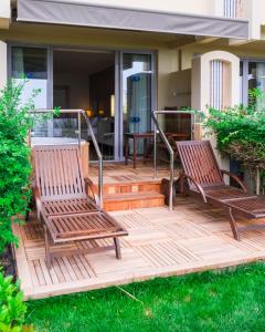 2 sillas de madera sentadas en una terraza frente a una casa en Melas Resort Hotel, en Side