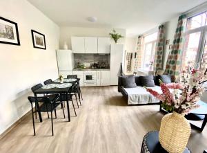 a living room with a couch and a table and chairs at Сarnot Apartments ZOO Area in Antwerp