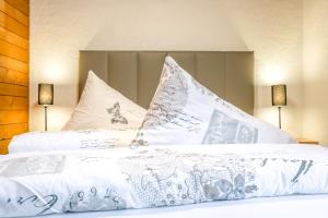 um quarto com uma cama com lençóis brancos e almofadas em First Apartment em Grindelwald