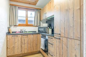 uma cozinha com armários de madeira e uma bancada em First Apartment em Grindelwald