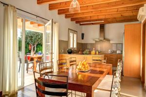 cocina y comedor con mesa de madera y sillas en Villa Serena Forcat by Villa Plus en Cala en Blanes