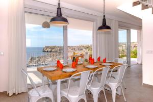 a dining room with a table and views of the ocean at Villa Aguamarina by Villa Plus in Cala en Forcat