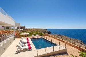 une villa avec une piscine et l'océan dans l'établissement Villa Aguamarina by Villa Plus, à Cala en Forcat
