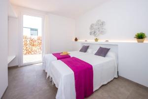two beds in a white room with a window at Villa Aguamarina by Villa Plus in Cala en Forcat +24 photos