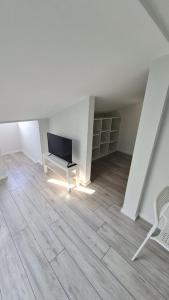 a living room with a flat screen tv in an attic at RYNEK 2 DUKLA- POKOJE I APARTAMENTY in Dukla