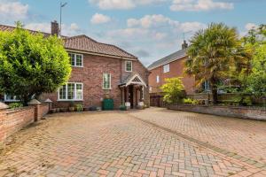 a brick house with a brick driveway at Church Lane Cottage - Norfolk Holiday Properties in Filby