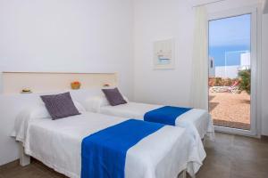 2 Betten in einem Zimmer mit Fenster in der Unterkunft Villa Amatista by Villa Plus in Cala en Forcat